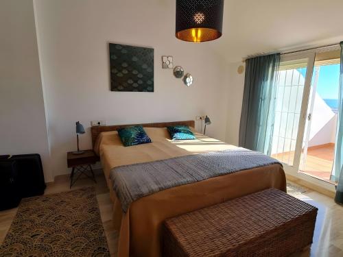 een slaapkamer met een bed en een groot raam bij Duplex Penthouse With 4 Bedrooms in Arroyo de la Miel
