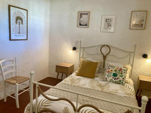 a bedroom with a white bed and a chair at Idyllique ! Terrasse vue jardin et montagne, parking, local à vélos, à 2 pas de la plage et piscine de mai à septembre ! in Argelès-sur-Mer