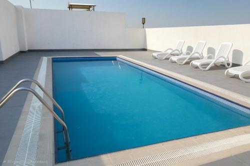 a swimming pool with white chairs next to it at City Stay Dubai South - Serviced Apartments in Dubai