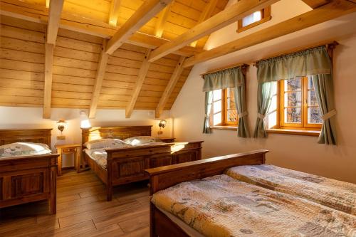 een slaapkamer met 3 bedden en houten plafonds bij Dřevěnka pod strání in Cerny Dul