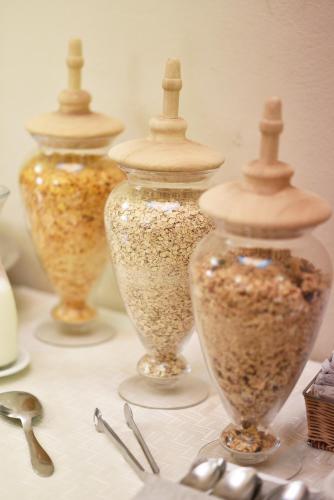 a group of four glass jars filled with seeds at Hotel San Nicola in Altamura