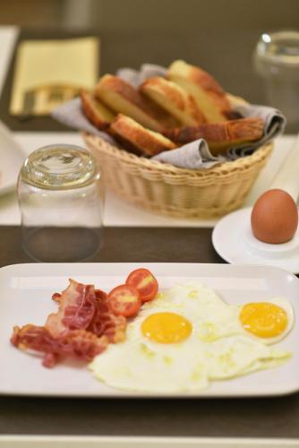 a plate of food with eggs and a basket of bread at Hotel San Nicola in Altamura