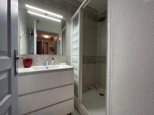 une salle de bains avec un lavabo blanc et une douche dans l'établissement Maison dans résidence CopaCabana, à Saint Pierre La Mer