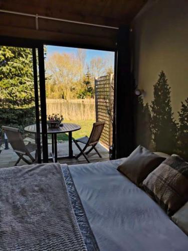 a bedroom with a bed and a patio with a table at Domaine des Pins La cabane au bord de l'eau 