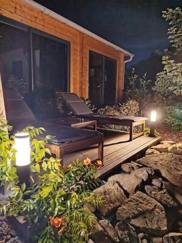 a wooden deck with two benches and two lights at Domaine des Pins La cabane au bord de l'eau 