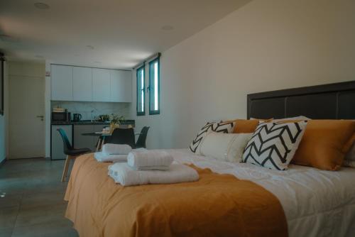 a bedroom with a large bed with towels on it at Lodwine Lodge Apartments in Ciudad Lujan de Cuyo