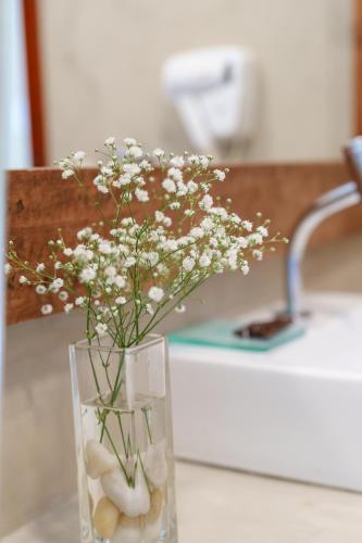 a vase filled with white flowers sitting on a counter at Casa Mar Villas in Florianópolis