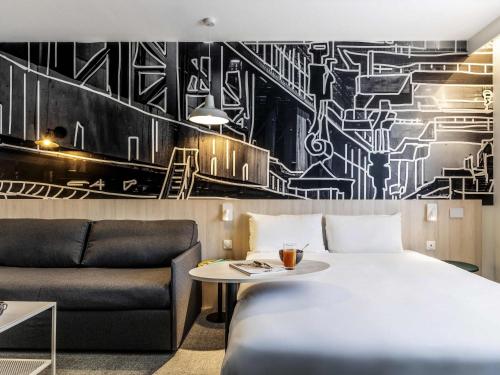 una habitación de hotel con una cama y un sofá en ibis Styles Limoges Centre, en Limoges