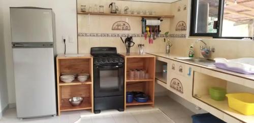 a kitchen with a black stove and a refrigerator at El Sol del Cuyo in El Cuyo