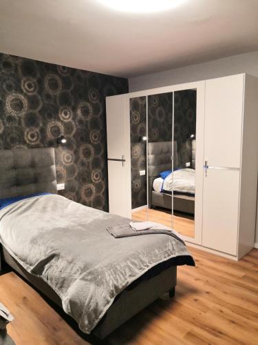 a bedroom with a bed and a mirrored wall at Schöne Ferienwohnung in Schwerte Central in Schwerte