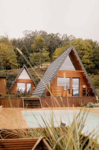 a house with a pitched roof and a deck at Casas da Madrinha in Arcos de Valdevez