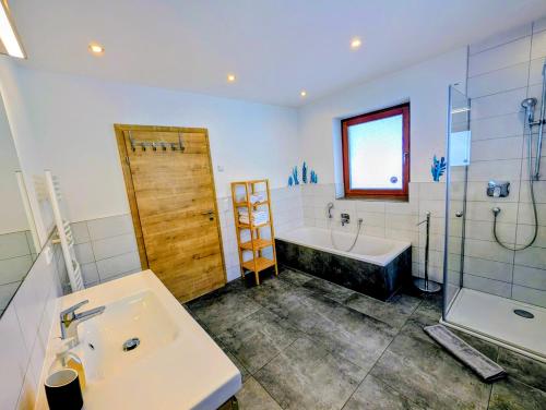 Un baño con lavabo, bañera y ducha. en Haus Dirol, en Kirchberg in Tirol