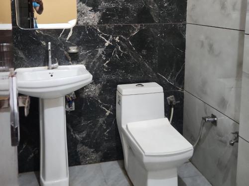 ein Badezimmer mit weißer Toilette und Waschbecken in der Unterkunft Panipat Town House - Top Rated Property of Panipat in Pānīpat