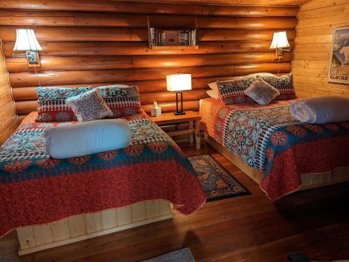 a bedroom with two beds in a log cabin at Laughing Horse Lodge in Bigfork