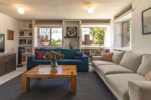 a living room with a blue couch and a table at Casa Rosa in Querétaro