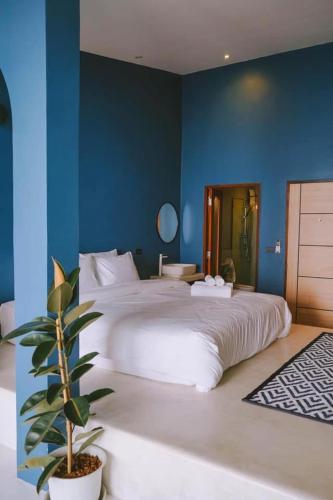 a bedroom with a large white bed with a potted plant at Radda Sea House in Ko Larn