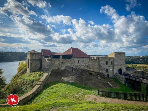 an old castle on the edge of a body of water at Nastawka Cottage Creativity and Regeneration in Raciechowice