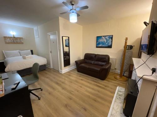 a bedroom with a bed and a couch and a chair at Shooters Hill Stay in London