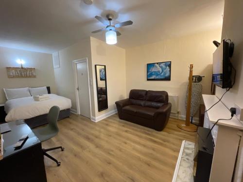 a bedroom with a bed and a couch and a chair at Shooters Hill Stay in London