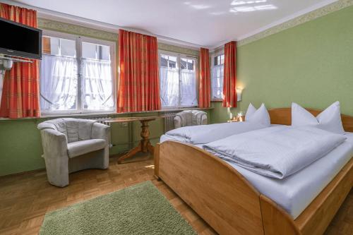 een slaapkamer met een bed, een bureau en ramen bij Hotel Bären Meersburg in Meersburg