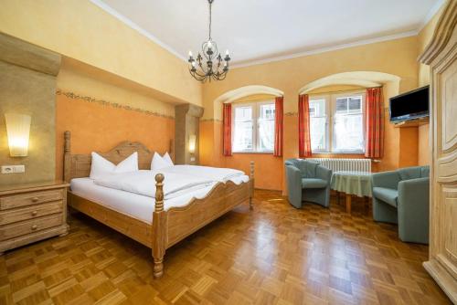 een slaapkamer met een bed, een tafel en stoelen bij Hotel Bären Meersburg in Meersburg