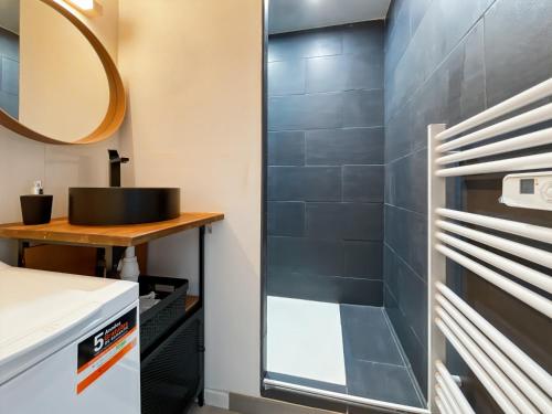 een badkamer met een wastafel en een spiegel bij Duplex - Place du Parlement de Bretagne - Hyper Centre de Rennes in Rennes