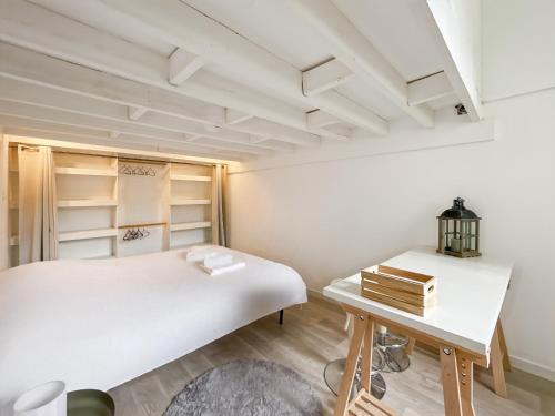 een slaapkamer met een wit bed en een bureau bij Duplex - Place du Parlement de Bretagne - Hyper Centre de Rennes in Rennes