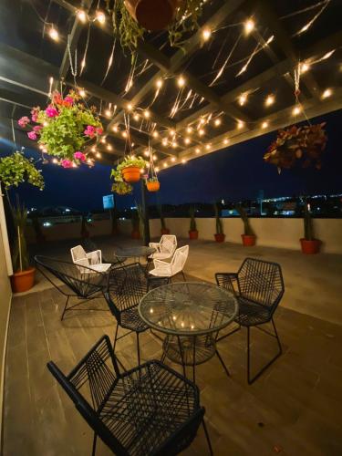 a patio with a table and chairs and lights at Living Alameda in Querétaro