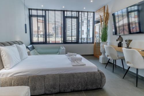 ein Schlafzimmer mit einem Bett und einem Tisch und Stühlen in der Unterkunft Timeless luxury suites & SPA in Thessaloniki