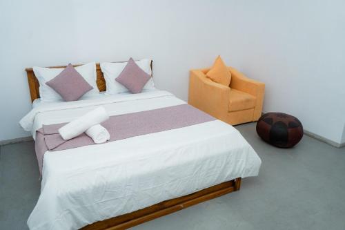 a bedroom with a bed with a chair and a soccer ball at Rest Ahangama in Ahangama