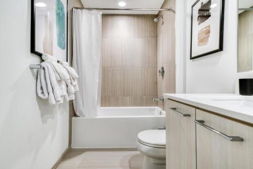 a white bathroom with a toilet and a sink at Blueground Hunter Mill District pool nr Lake Anne WDC-844 in Reston