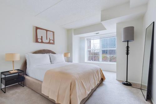 a white bedroom with a bed and a window at Blueground Hudson Exchange pool nr Liberty Park NYC-2174 in Hoboken
