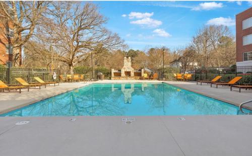 a swimming pool with chairs and a building at Pet Friendly Duke 1br - Near Hospital and Downtown in Durham