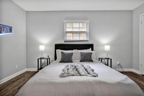 a white bedroom with a large bed with a blanket at Pet Friendly Duke 1br - Near Hospital and Downtown in Durham