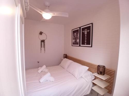een kleine slaapkamer met een bed met witte lakens bij Amanecer Andaluz in Ronda