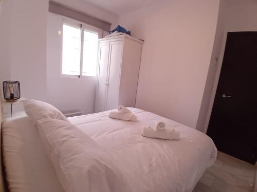 een wit bed met twee handdoeken erop bij Amanecer Andaluz in Ronda