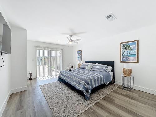 Un dormitorio blanco con una cama y un ventilador de techo. en 3BR Lake Front Getaway, en North Lauderdale