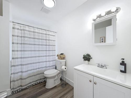 Un baño con inodoro, lavabo y espejo. en 3BR Lake Front Getaway, en North Lauderdale