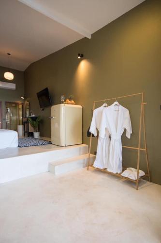 a bedroom with a room with a bed and white clothes at Radda Sea House in Ko Larn