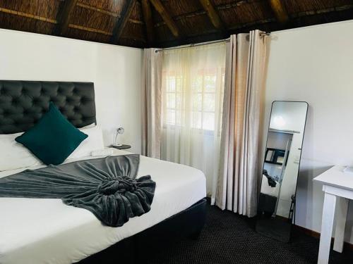 a bedroom with a large bed and a window at Sagrada Guest House in Mthatha