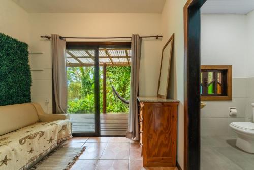 Coração da Terra Praia do Rosa في برايا دو روزا: حمام به مرحاض وباب زجاجي منزلق