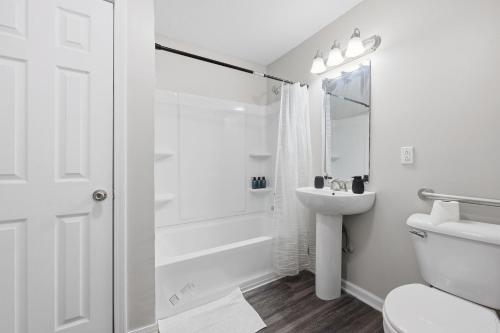 een witte badkamer met douche en wastafel bij Modern Highland Park 2BR 2BA Stay in Clarksville