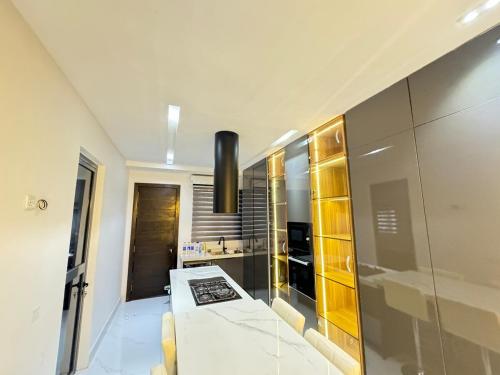 a living room with a large mirror and a kitchen at Dazzling Lekki 3BR Home - Private Balcony - 247 Power, Wifi & Security in Lekki