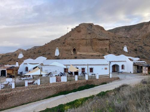 a white building with a mountain in the background at Bike Cueva - Badlands in Gorafe