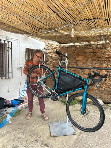a man is holding a bike in a garage at Bike Cueva - Badlands in Gorafe