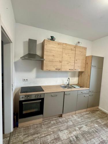 a kitchen with a sink and a stove and cabinets at Apartment im Grünen in Kroppach
