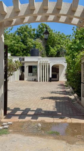 a white building with an archway in front of it at Villa Carino Kilifi Kenya in Kilifi