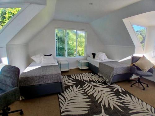 a bedroom with two beds and a chair and a rug at Providence in Hermanus