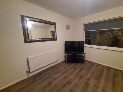 a living room with a television and a mirror at Comfortable two bed apartment in Chester-le-Street