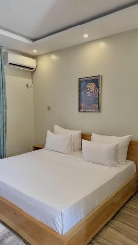 a large white bed with white pillows in a room at Villa Carino Kilifi Kenya in Kilifi